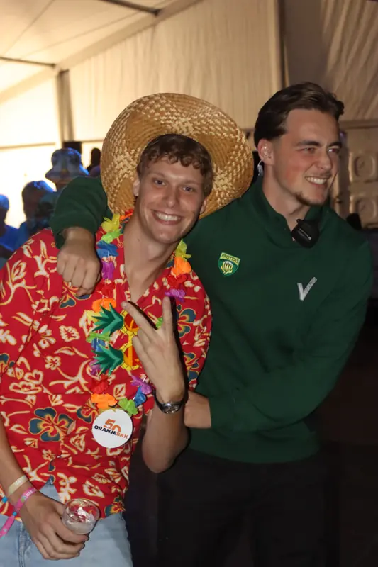 Proteas medewerkers met feestgangers tijdens een themafeest.